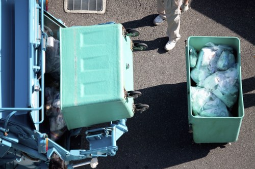 Workers sorting garden waste into separate bins during clearance